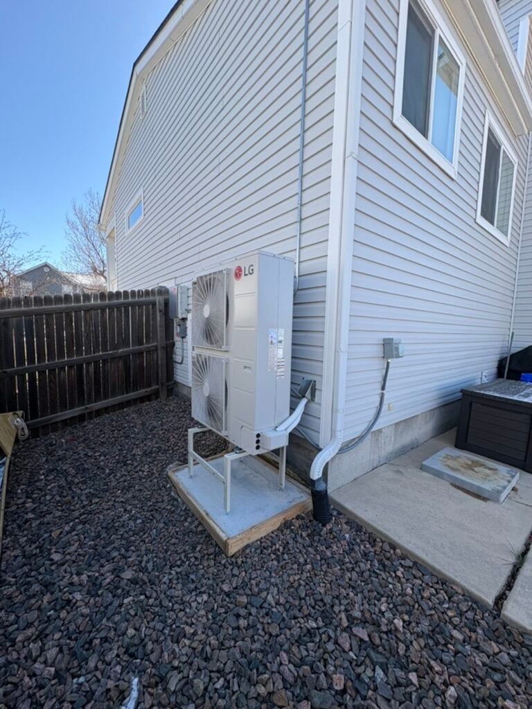 wider view of the new heat pump installed on our custom concrete pad