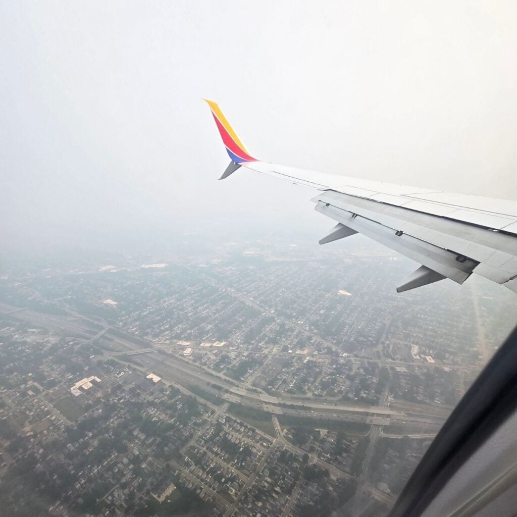 a view out of a Southwest airplane window showing nothing but smoke in the atmostphere.