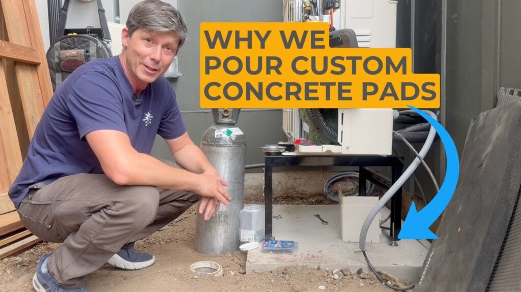Xerxes crouches near one of our heat pad condenser pads that is custom poured concrete