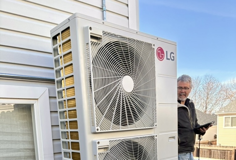 the hear inspector checking out the new lg red heat pump outside at chris's home