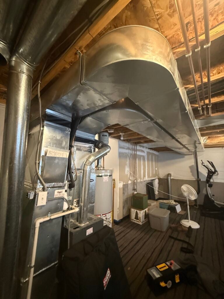 chris's open basement with the old natural gas furnace and water heater