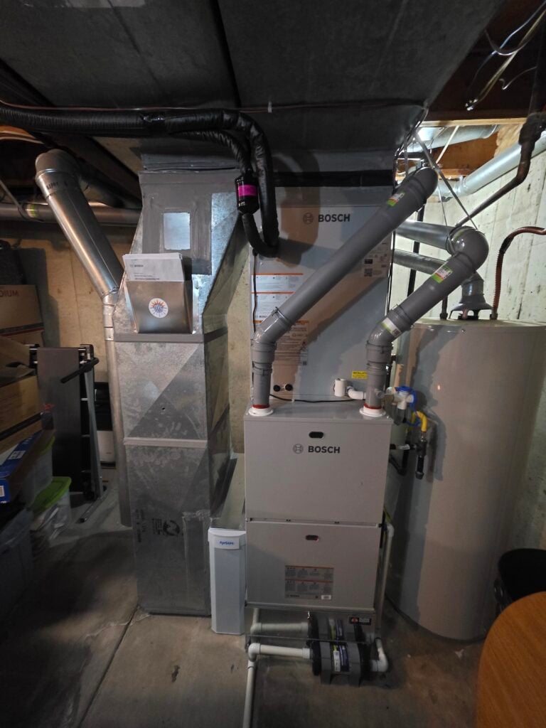 New Bosch dual-fuel furnace with AprilAire filter installed in David's basement, connected to the ductwork and next to the existing gas water heater.