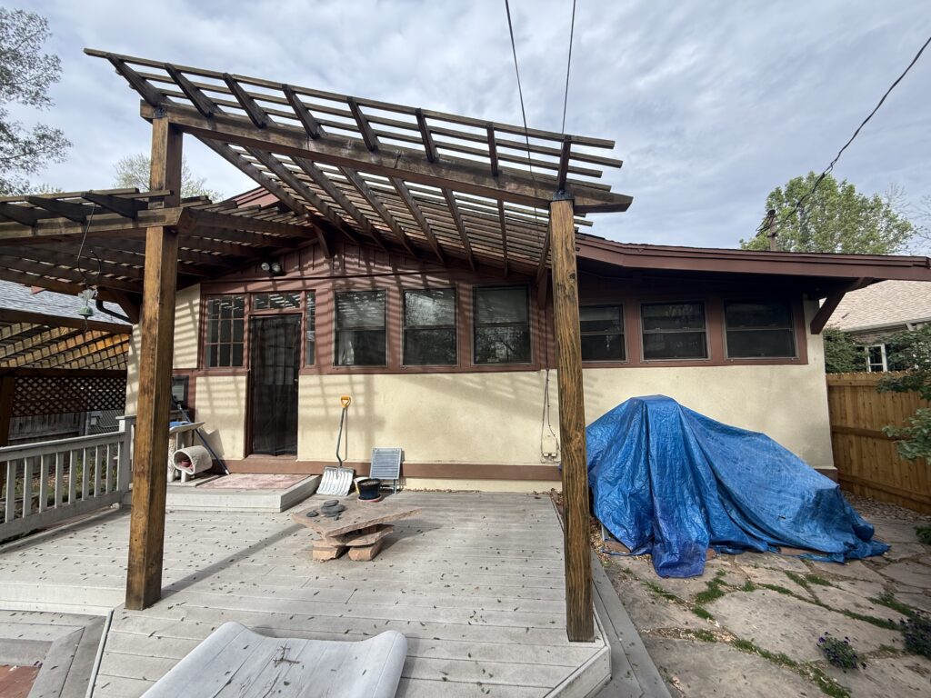 Backyard deck and pergola of a home before heat pump installation