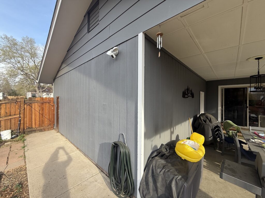 Side yard and patio of a gray home before heat pump installation