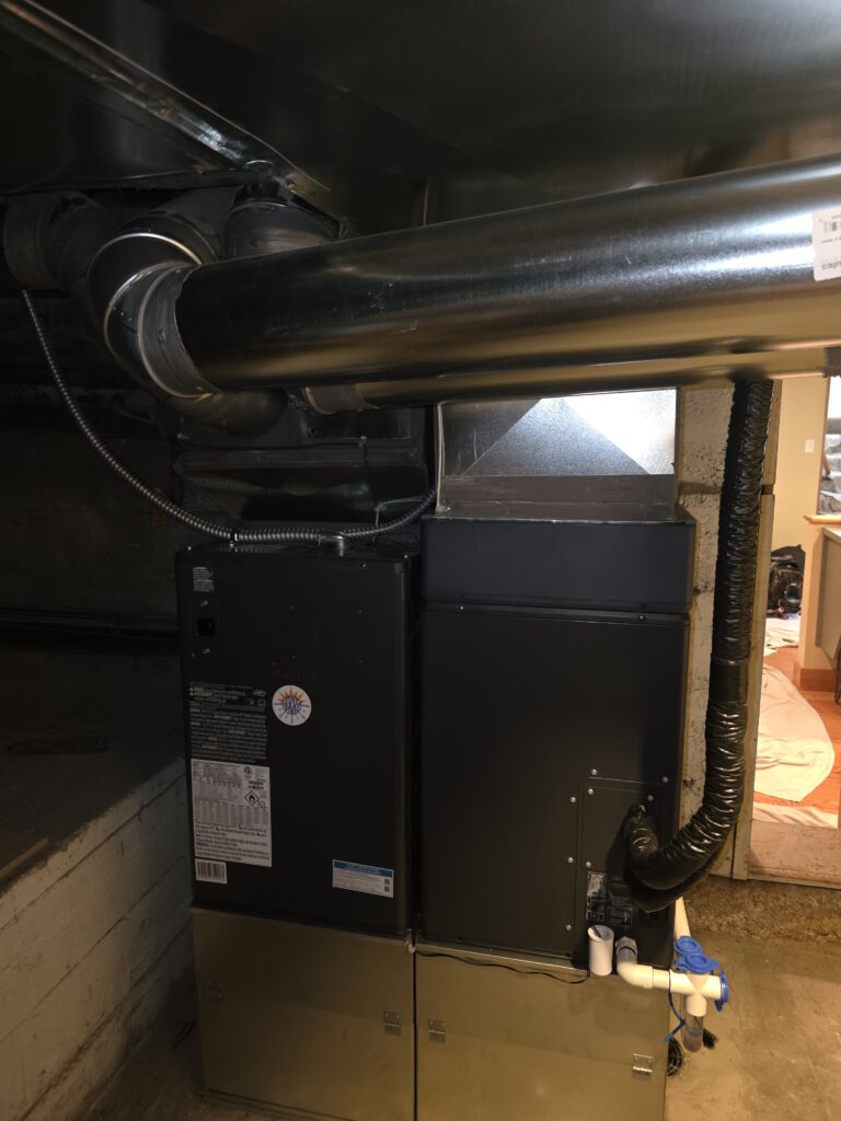 Installed Midea heat pump air handler with new ductwork connection and Just Heat Pumps label"