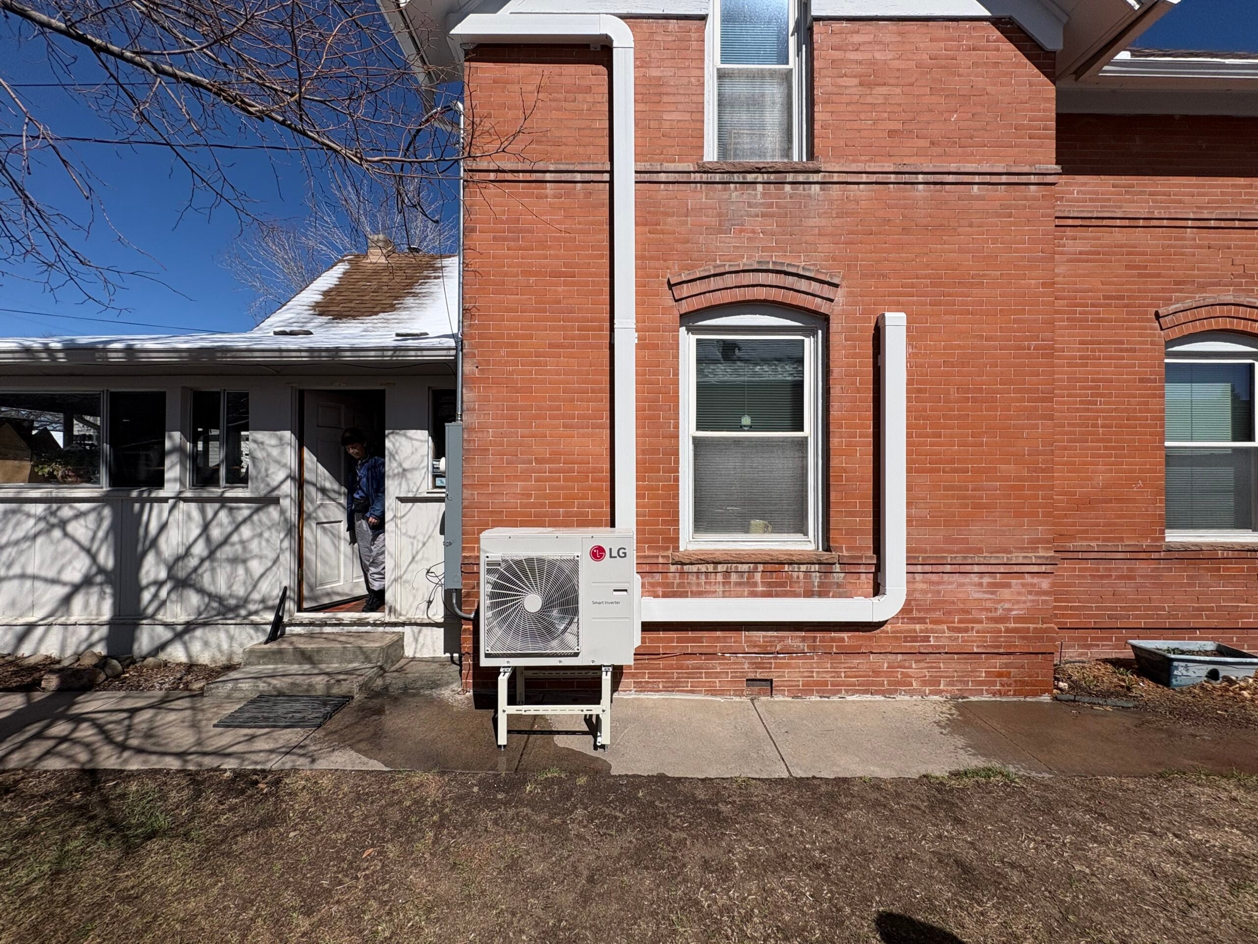 LG RED ductless mini split heat pump install in Littleton CO on a red brick home with linehide and lineset going up to each room