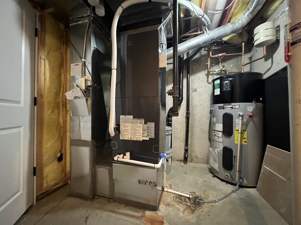 An LG air handler installed in the basement of a Park Hill Denver home next to an AO Smith heat pump water heater