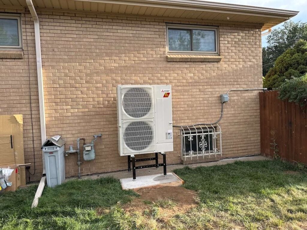 A Mitsubishi heat pump condenser installed on the side of a Lakewood, CO home that we installed