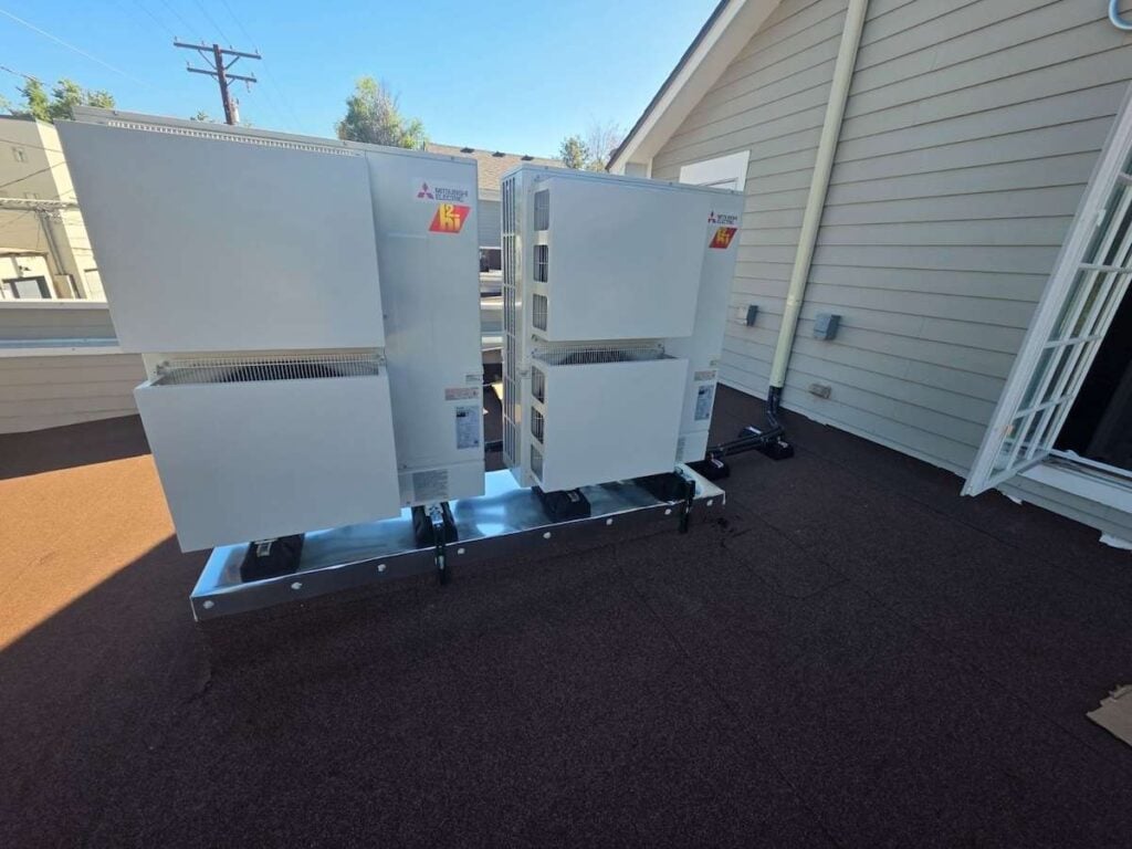 Two Mitsubishi heat pump condensers on the roof of our Cherry Creek Denver, CO customer's two-story home.