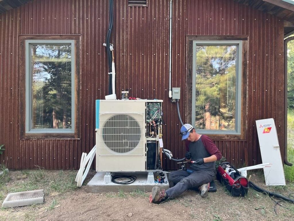 Xerxes, our cofounder, working on the copper refrigeration lines on an outdoor Mitsubishi heat pump that we installed.